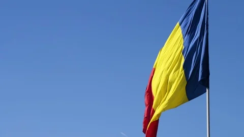 A flag on a pole waving in the sun with clear blue sky Stock Footage 98949025