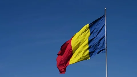 A flag on a pole waving in the sun with clear blue sky Stock Footage 98949032