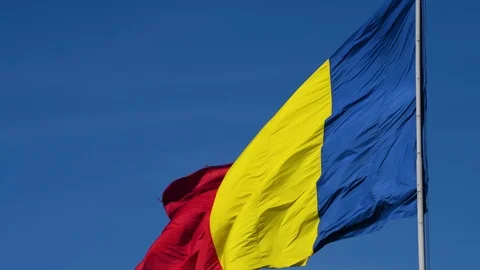 A flag on a pole waving in the sun with clear blue sky Stock Footage 98949034