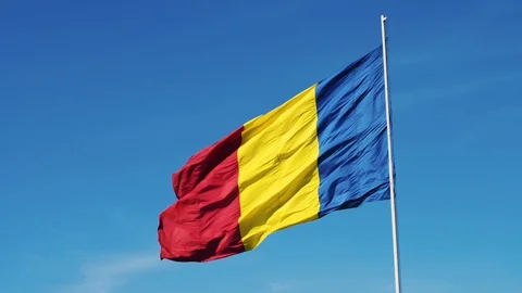 A flag on a pole waving in the sun with clear blue sky Stock Footage 98949058