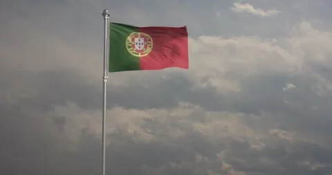 Flag of Portugal billows energetically in the wind against a steely grey sky 動画素材 240956209