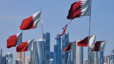 Flag of Qatar waving in wind with Doha downtown and skyscrapers in background Stock Footage 103947444