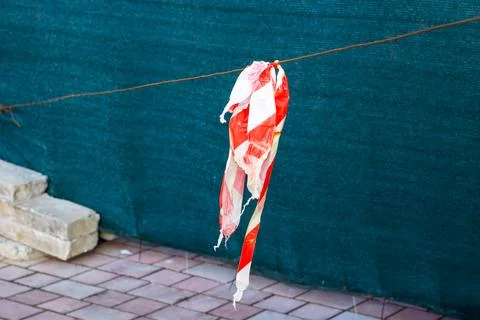 A flag that is red and white is currently hanging from a wire Stock Photos