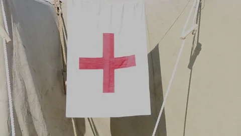 A flag with a red cross on a white background near the green building Stock Footage 76745103