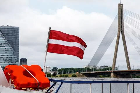 Flag of the Republic of Latvia. Cable-stayed bridge in Riga on the background Stock Photos