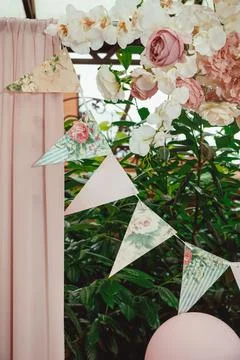 Flag ribbon with a pattern of roses on a background of greenery, a pink curta Stock Photos