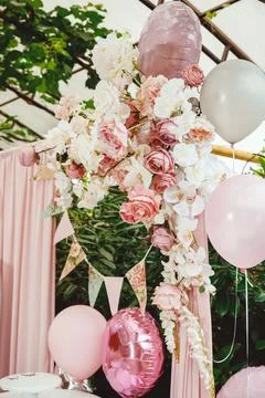 Flag ribbon with a pattern of roses on a background of greenery, a pink curta Stock Photos