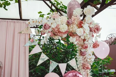 Flag ribbon with a pattern of roses on a background of greenery, a pink curta Stock Photos