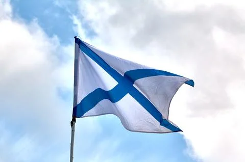 The flag of the Russian navy develops against the sky Stock Photos