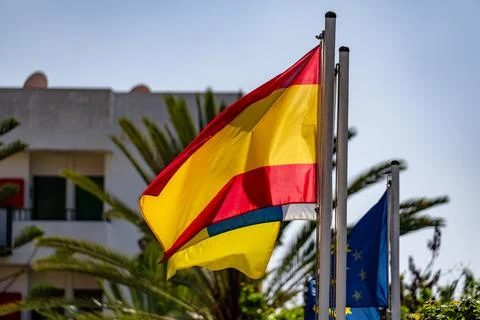 Flag of Spain waving in the wind on flagpole against the sky with clouds on Stock Photos