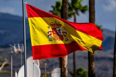 Flag of Spain waving in the wind on flagpole against the sky with clouds on 스톡 사진