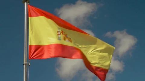 Flag of Spain waving in the wind over a blue sky Stock Footage 74959044
