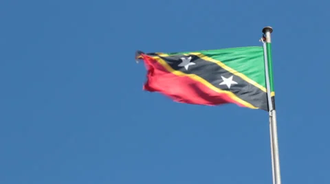 Flag of St. Kitts Blowing in the Breeze with Blue Sky Background Stock Footage 36778970