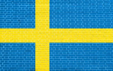 Flag of Sweden on brick wall texture background. Swedish national flag. Illustrazione stock