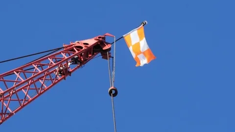 Flag on top of a tall crane at a construction site Stock Footage 80063849