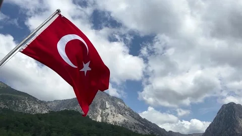 The flag of Turkey against the background of the sky and mountains. Slow motion Stock Footage 187455988