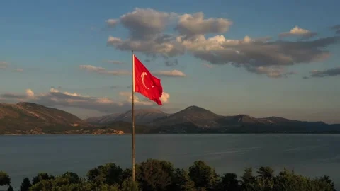 The flag of Turkey is fluttering in the wind among the beautiful landscape of Stock Footage 221043747