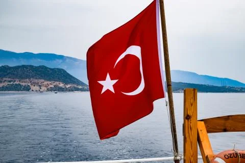 The flag of Turkey flutters in the wind on the deck of pleasure yacht. Stock Photos