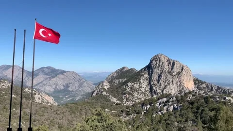 Flag of turkey waving in the wind against the sky and mountain 4K 60fps Stock Footage 148043772