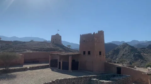 Flag of the UAE is waving on top of Al Hayl fort watchtower. Fujairah, UAE Stock Footage 300032470