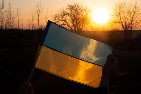 Flag Ukraine against the backdrop of the setting sun of a free european country Stock Photos