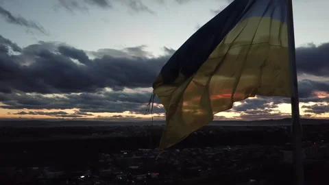 The flag of Ukraine on the background of the sunset. Torn flag. Dramatic scene Video stock 268322868