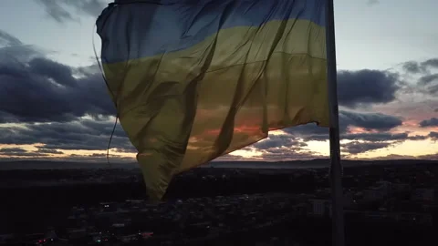 The flag of Ukraine on the background of the sunset. Torn flag. Dramatic scene Video stock 268322940