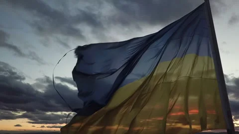 The flag of Ukraine on the background of the sunset. Torn flag. Dramatic scene Video stock 268323001