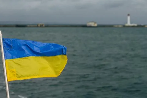 Flag of Ukraine is developing against the background of the sea and the sea ligh Stock Photos
