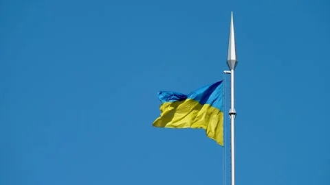 The flag of Ukraine flutters on a flagpole, during the day against a blue sky. Stock Footage 239759341