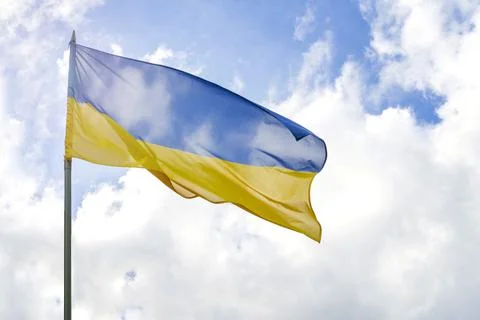 Flag of Ukraine in front of cloudy and sunny blue sky Stock Photos