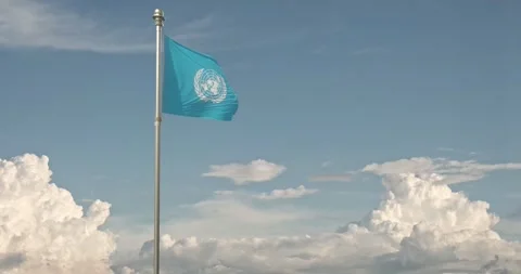 The flag of UN flies against a background of rolling cumulus clouds Stock Footage 241837979