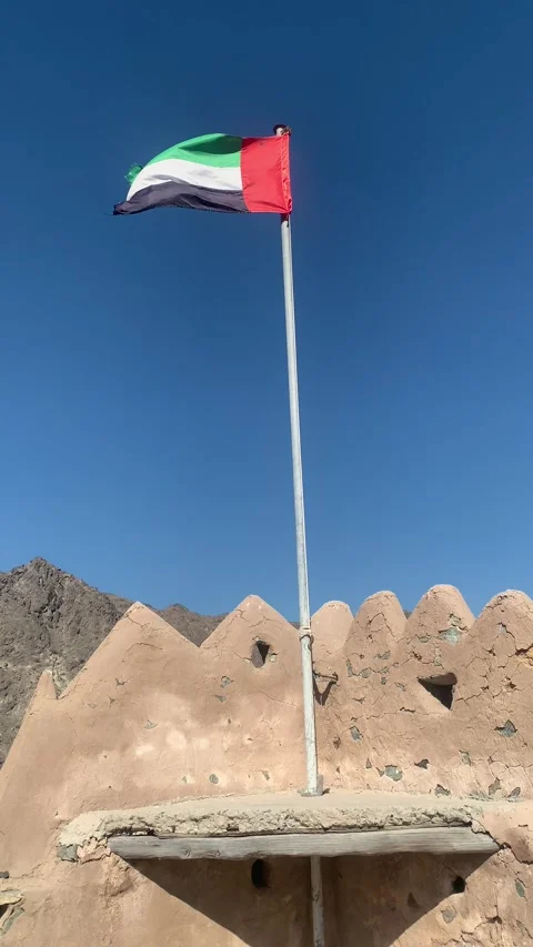 Flag of the United Arab Emirates (UAE) is waving on top of Al Hayl fort Stock Footage 300034475