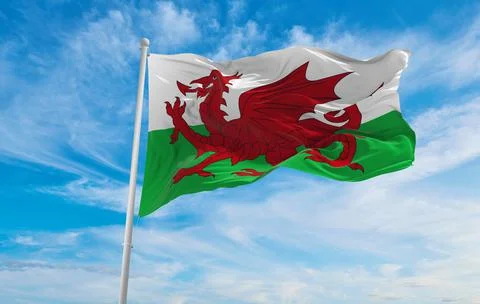 Flag of Wales  at cloudy sky background on sunset, panoramic view. united kin Stock Illustration