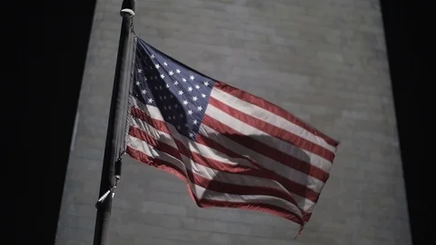 A flag waves in slow motion in front of the Washington Monument Stock Footage 118831829