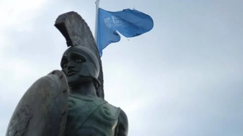 Flag waving behind the statue of a soldier from Greece 库存影片 157696933