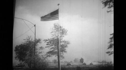 Flag waving in wind and tanks rolling in background Stock Footage 39932782