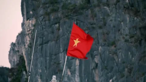 On a flagpole on a ship, the Vietnamese flag flutters in the wind Stock Footage 303177706
