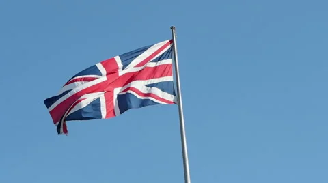 Flagpole with Union Jack British flag against a blue sky Stock Footage 55407579