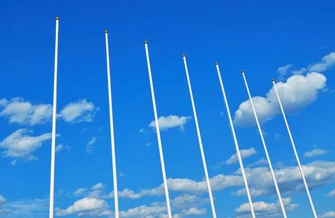 Flagpoles without flags on a background of blue sky Stock Photos