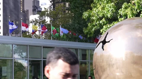 Flags and bronze sphere sculpture at UN headquarters Video stock 346265214