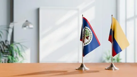 FLAGS OF BELIZE AND COLOMBIA ON TABLE Stock Photos