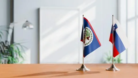 FLAGS OF BELIZE AND SLOVENIA ON TABLE Stock Photos