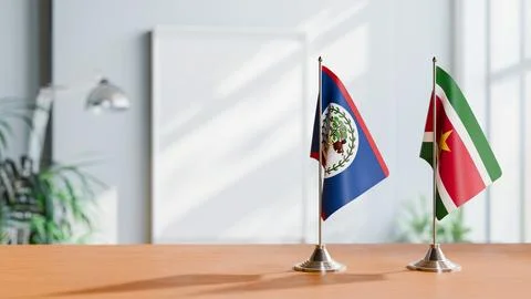 FLAGS OF BELIZE AND SURINAME ON TABLE Stock Photos