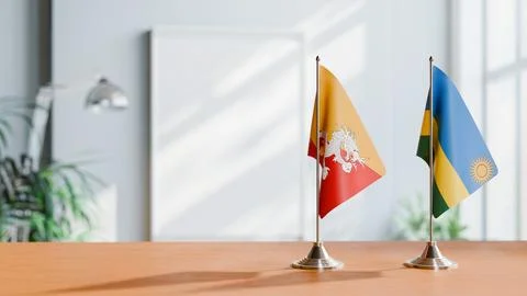 FLAGS OF BHUTAN AND RWANDA ON TABLE Stock Photos