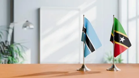 FLAGS OF BOTSWANA AND SAINT KITTS ON TABLE Stock Photos