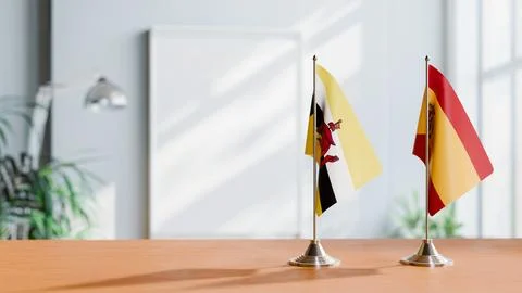 FLAGS OF BRUNEI AND SPAIN ON TABLE Stock Photos