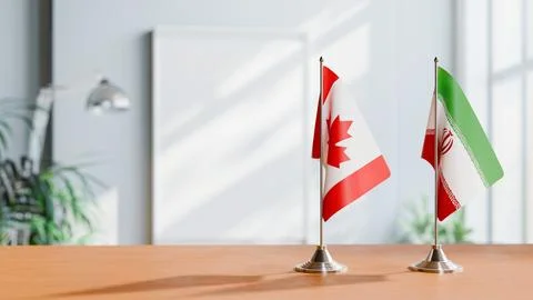 FLAGS OF CANADA AND IRAN ON TABLE Stock Photos