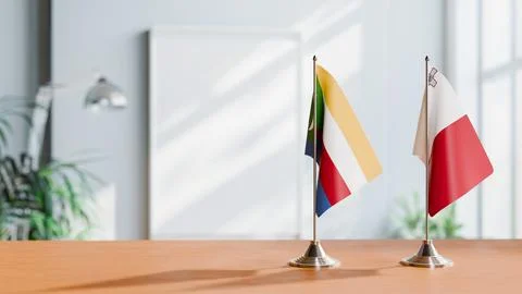 FLAGS OF COMOROS AND MALTA ON TABLE Stock Photos