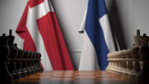 Flags of Denmark and Finland behind pawns on the chessboard. Chess game or Stock Footage 116885885